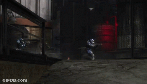 A Man In A Blue Helmet Is Holding A Gun In A Field . GIF