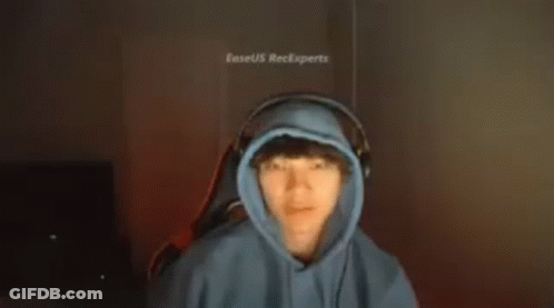 A Man In A Blue Hoodie And Headphones Is Making A Funny Face . GIF