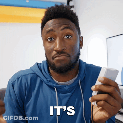 A Man In A Blue Hoodie Holds A Remote Control And Says It 'S In White Letters GIF