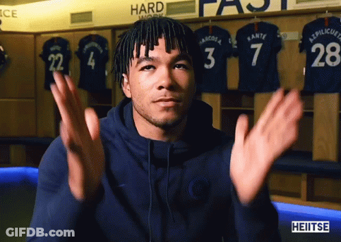 A Man In A Blue Hoodie Is Clapping In Front Of A Sign That Says Hard GIF