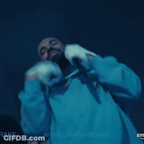 A Man In A Blue Hoodie Is Holding A Microphone With The Hashtag #Freelarryhoover On The Bottom GIF