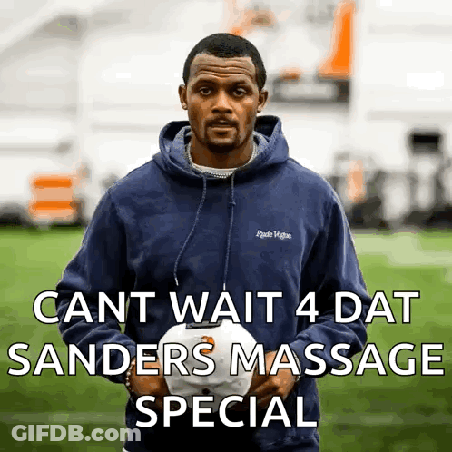 A Man In A Blue Hoodie Is Holding A White Hat With The Words Cant Wait 4 Dat Sanders Massage Special GIF