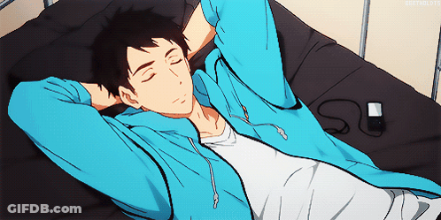 A Man In A Blue Hoodie Is Laying On A Bed With His Eyes Closed GIF