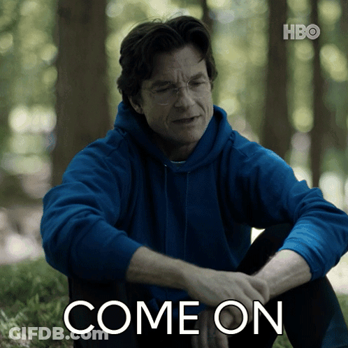A Man In A Blue Hoodie Is Sitting In The Grass With The Words Come On Written Below Him GIF