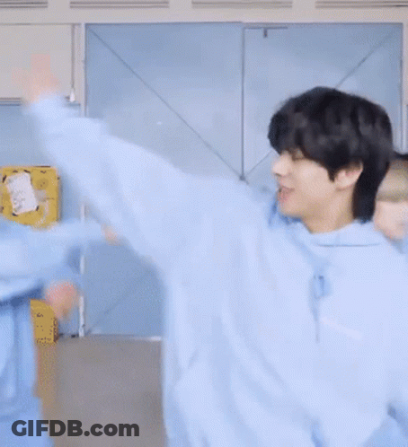 A Man In A Blue Hoodie Is Smiling And Looking At The Camera GIF