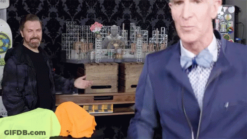 A Man In A Blue Jacket And Bow Tie Is Standing Next To Another Man GIF