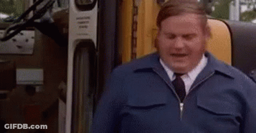 A Man In A Blue Jacket And Tie Is Sitting In Front Of A Truck And Says `` Good '' . GIF
