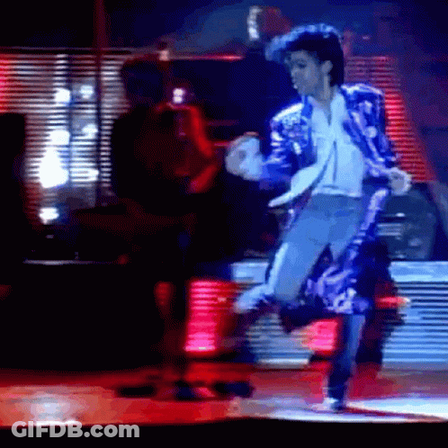 A Man In A Blue Jacket And White Shirt Is Dancing On Stage GIF