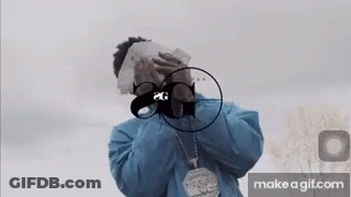 A Man In A Blue Jacket Is Covering His Face With Money And A Gun . GIF