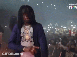 A Man In A Blue Jacket Is Dancing In A Crowd GIF