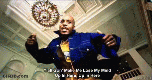 A Man In A Blue Jacket Is Dancing In A Room With A Chandelier In The Background GIF