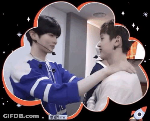 A Man In A Blue Jacket Is Hugging Another Man In A White Shirt With A Rocket In The Background GIF