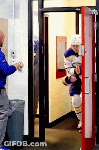 A Man In A Blue Jacket Is Opening A Door GIF