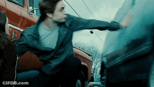 A Man In A Blue Jacket Is Reaching For A Car GIF