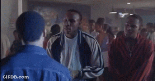 A Man In A Blue Jacket Is Standing In A Crowd GIF