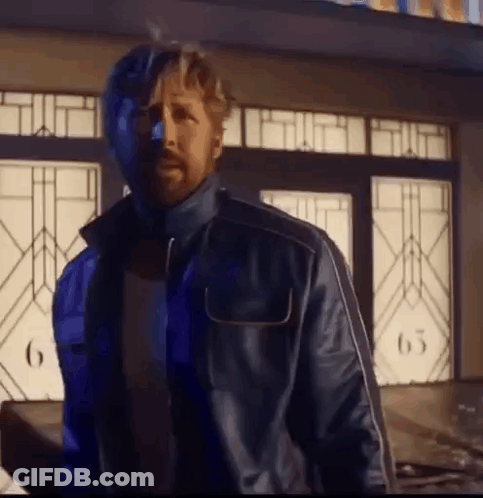 A Man In A Blue Jacket Is Standing In Front Of A Building With A Stained Glass Window . GIF