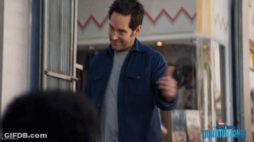 Man In Blue Jacket In Front Of Quantumania Building GIF