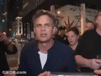 A Man In A Blue Jacket Is Standing In Front Of A Group Of People . GIF