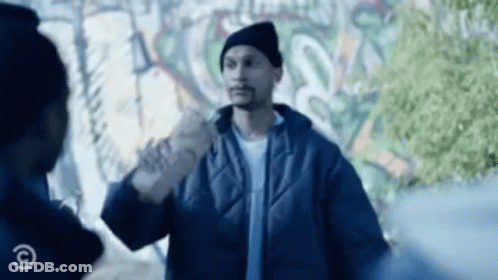 A Man In A Blue Jacket Is Standing Next To A Man In A Black Hat . GIF