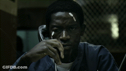A Man In A Blue Jacket Is Talking On A Telephone GIF
