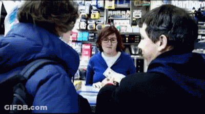 A Man In A Blue Jacket Is Talking To A Woman In A Store That Says Marlboro On The Wall GIF