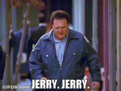 A Man In A Blue Jacket Is Walking Down A Street With The Words `` Jerry Jerry '' Written On It . GIF