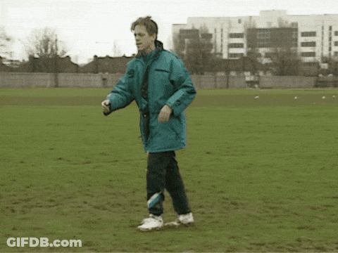 A Man In A Blue Jacket Kicking A Soccer Ball GIF