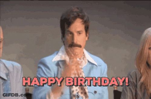 A Man In A Blue Jacket Says " Happy Birthday " In Red Letters GIF