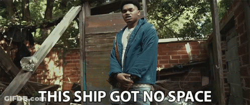 A Man In A Blue Jacket Stands In Front Of A Brick Wall With The Words This Ship Got No Space Below Him GIF