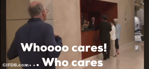 A Man In A Blue Jacket Stands In Front Of A Sign That Says Who Cares Who Cares GIF