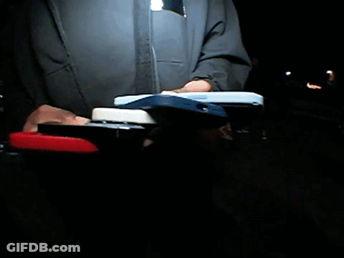 A Man In A Blue Jacket Stands In Front Of A Stadium GIF