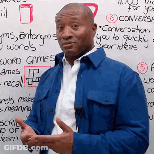 A Man In A Blue Jacket Stands In Front Of A White Board That Says Conversation GIF