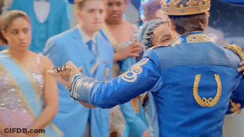 A Man In A Blue Jacket With A Horseshoe On The Back Is Holding A Woman 'S Hand GIF