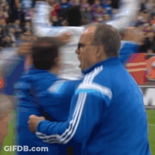 A Man In A Blue Jacket With White Stripes On The Side GIF