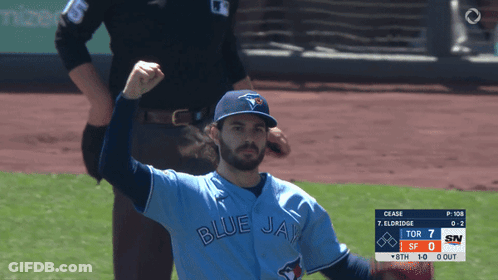 A Man In A Blue Jays Jersey Holds Up His Fist GIF