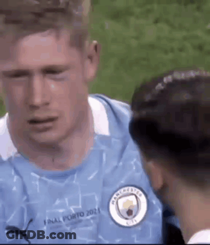 A Man In A Blue Jersey Is Crying While Talking To Another Man . GIF