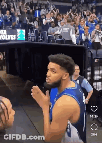 A Man In A Blue Jersey With The Number 1 On It Stands In Front Of A Crowd GIF