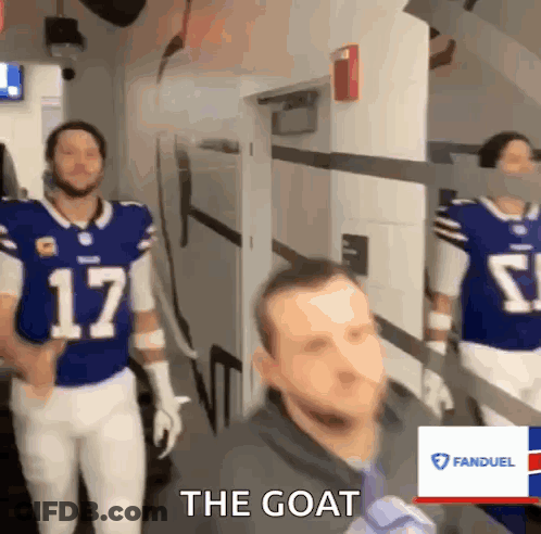 A Man In A Blue Jersey With The Number 17 On It Walks Down A Hallway GIF