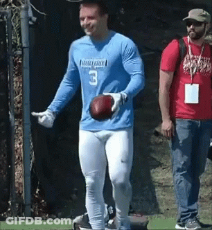 A Man In A Blue Jersey With The Number 3 On It Is Holding A Football . GIF