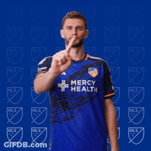 A Man In A Blue Mercy Health Jersey Holds Up A Finger GIF