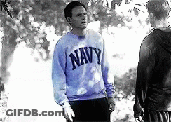 A Man In A Blue Navy Sweatshirt Stands Next To Another Man GIF