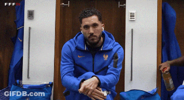 A Man In A Blue Nike Jacket Sits In A Changing Room GIF
