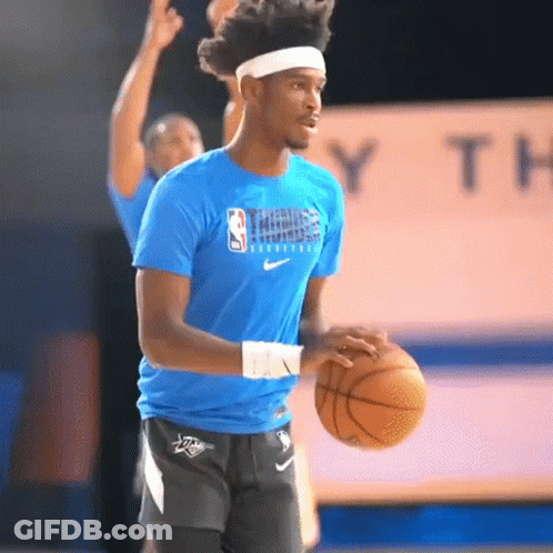 A Man In A Blue Nike Shirt Is Holding A Basketball GIF