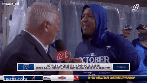 A Man In A Blue October Shirt Is Being Interviewed By A Man In A Suit GIF