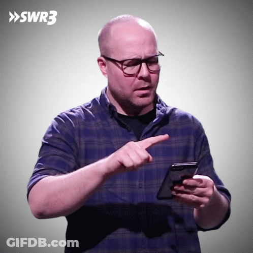 A Man In A Blue Plaid Shirt Is Pointing At A Cell Phone With Swr3 Written On The Bottom GIF