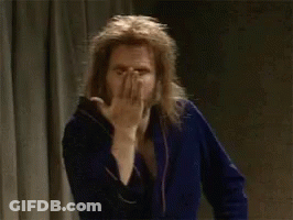 A Man In A Blue Robe Is Making A Wink Sign With His Finger GIF