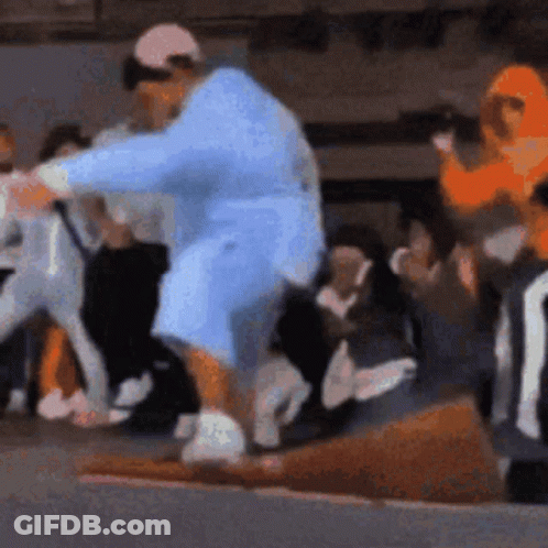 A Man In A Blue Robe Is Standing In Front Of A Crowd Of People . GIF