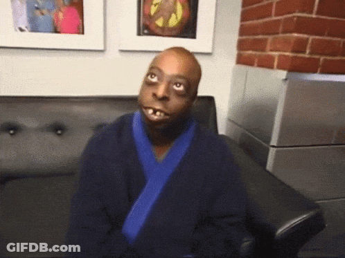A Man In A Blue Robe Sits On A Couch GIF