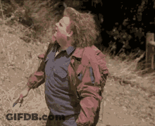 A Man In A Blue Shirt And A Red Jacket Is Holding A Knife GIF