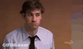 A Man In A Blue Shirt And Black Tie Is Making A Face . GIF